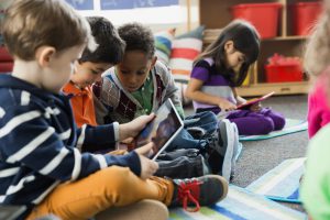 Boys using digital tablet together in elementary school