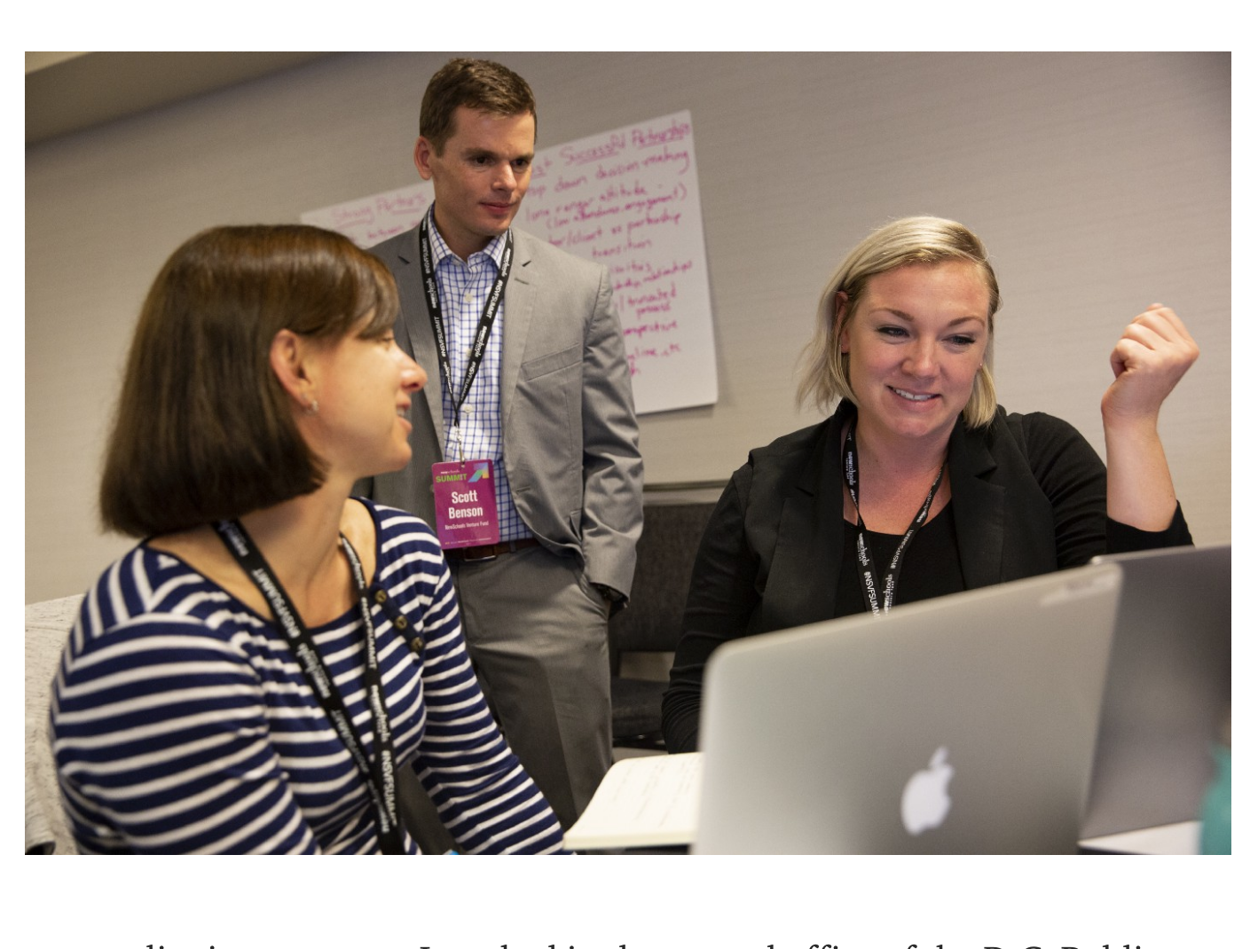 Two women and a man working together in a conference room