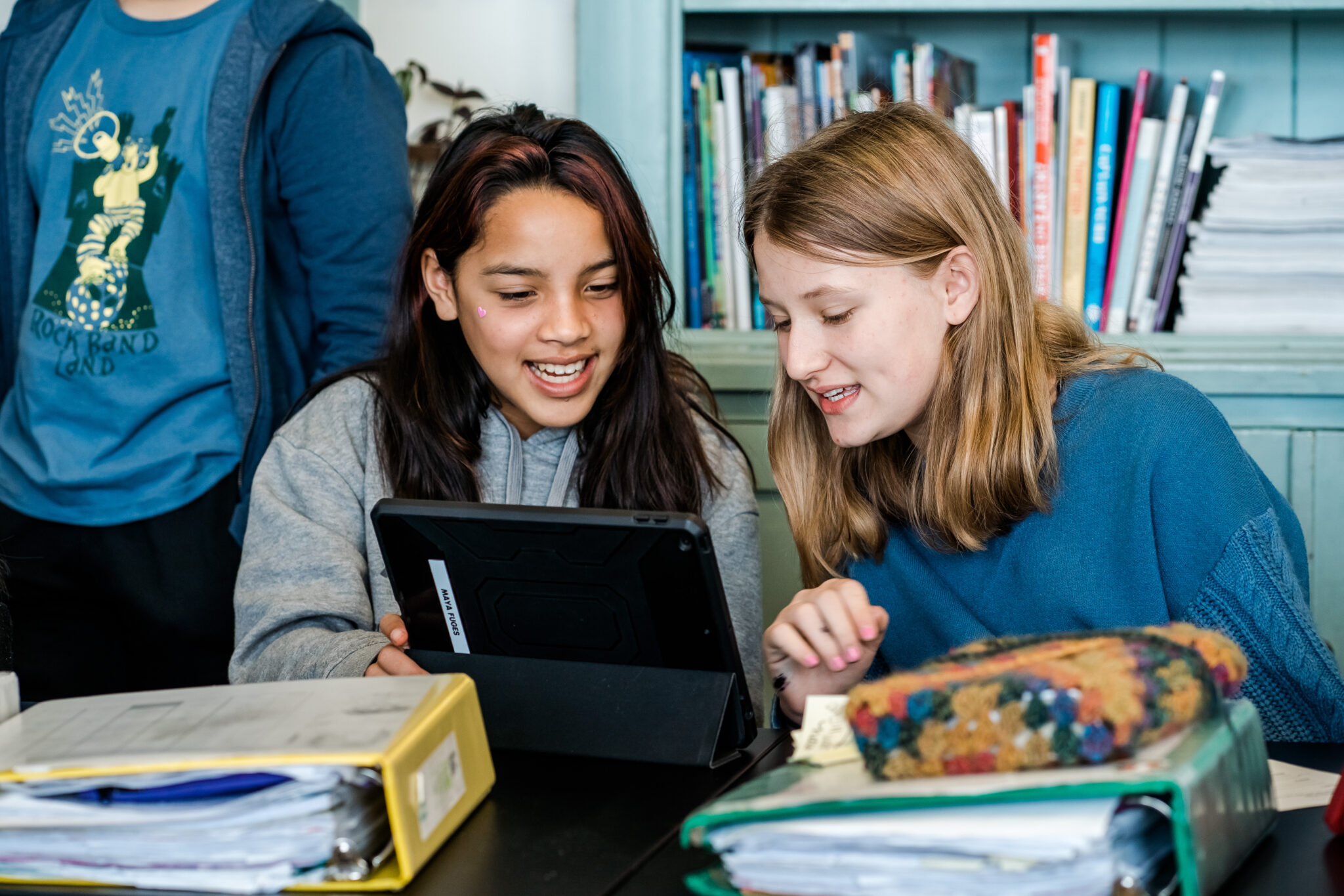 Two students smiling and looking at a laptop